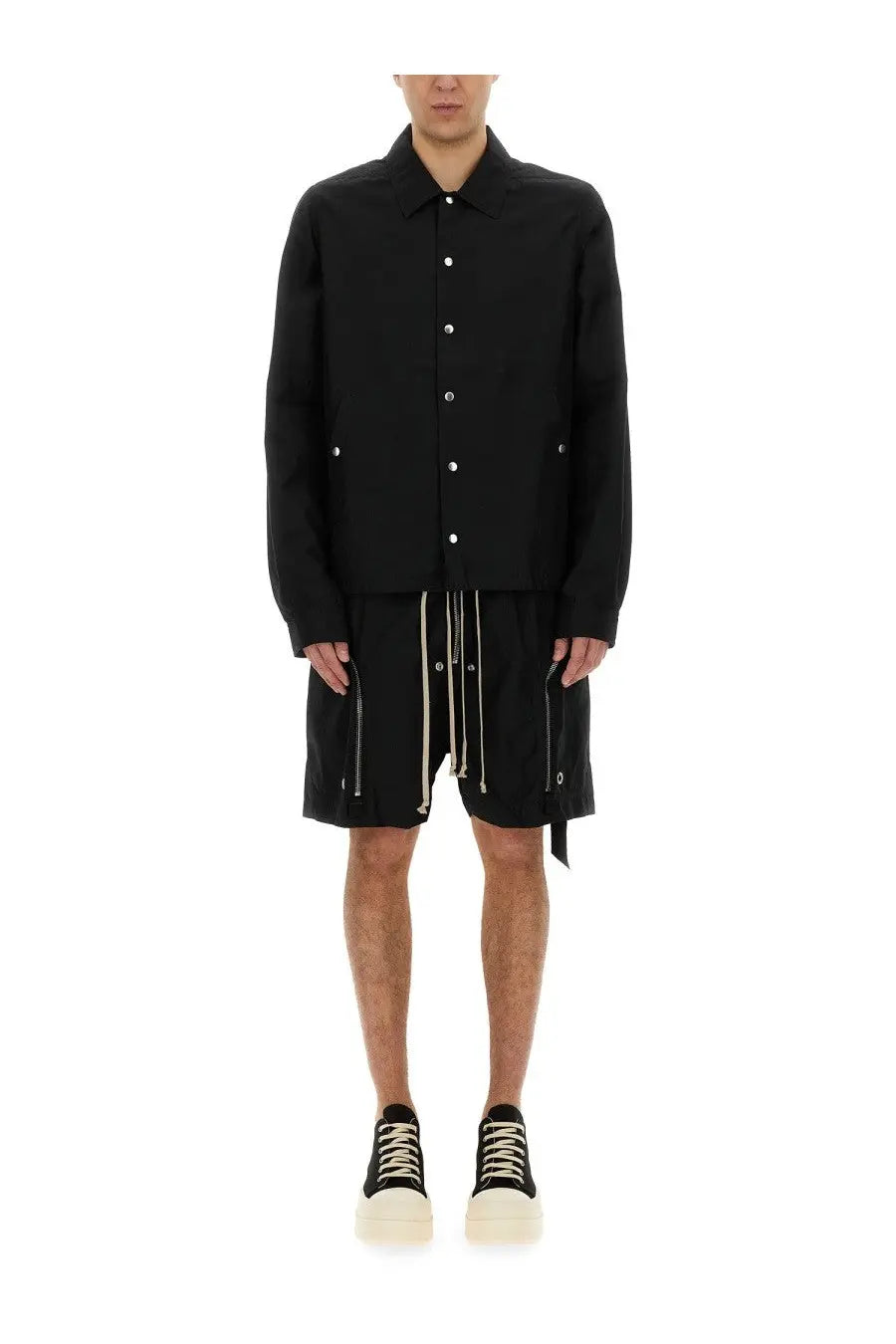 Drkshdw men’s black long-sleeved buttoned jacket with silver buttons and side pockets worn with matching shorts