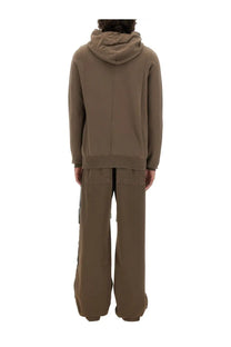 Drkshdw men’s gimp sweatshirt beige in muted olive green with central seam hood and ribbed cuffs paired with striped wide-leg pants