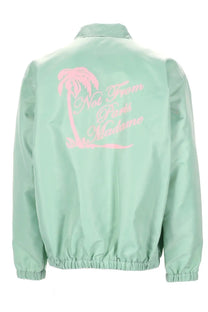 Back of mint green nylon coach jacket with pink palm tree and script text graphic by Drôle de Monsieur