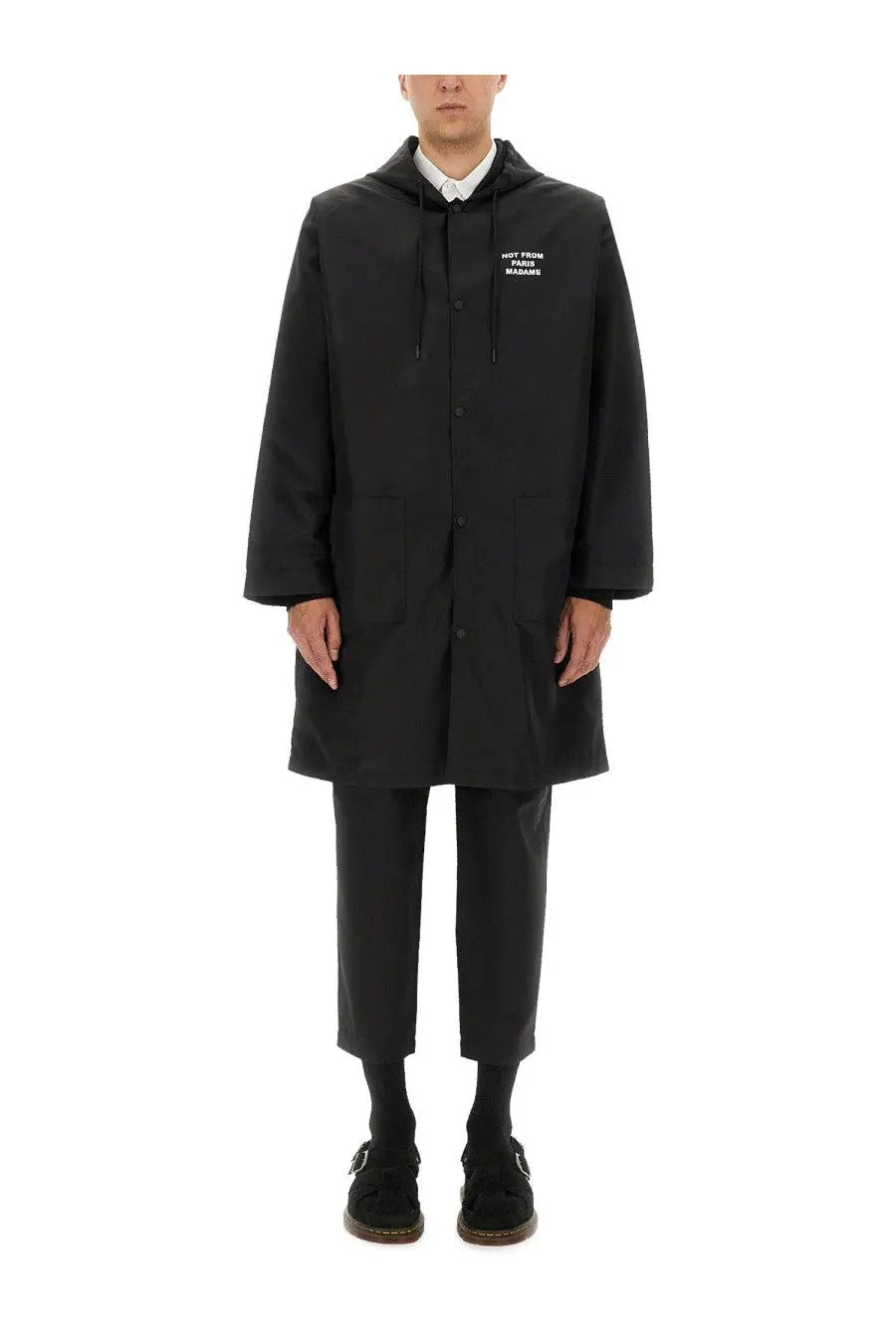 Black hooded men’s parka by drôle de monsieur with button closures and subtle white chest text in minimalist design