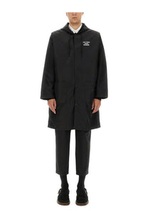 Black hooded men’s parka by drôle de monsieur with button closures and subtle white chest text in minimalist design