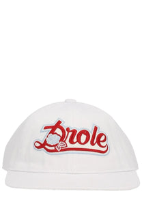 White baseball cap by drôle de monsieur featuring red and light blue embroidered drôle logo with rose design