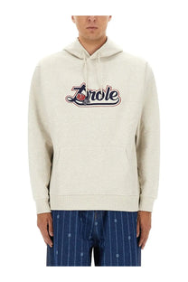 Cream-colored textured cotton hoodie with bold embroidered zorele logo red rose and navy blue lettering from drôle de monsieur