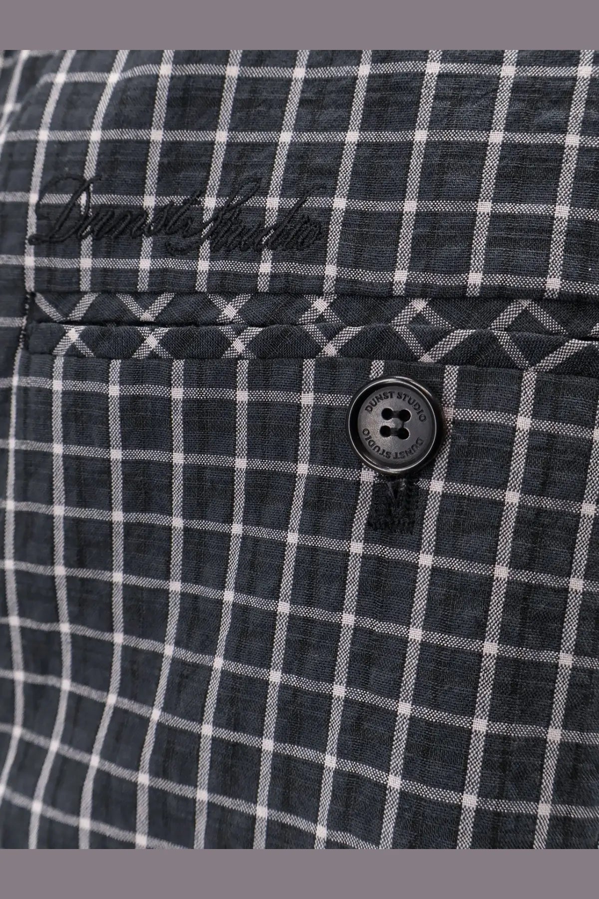 Dark gray and white checkered linen shirt with black dust studio button paired with dunst men’s unisex black pajamas trousers