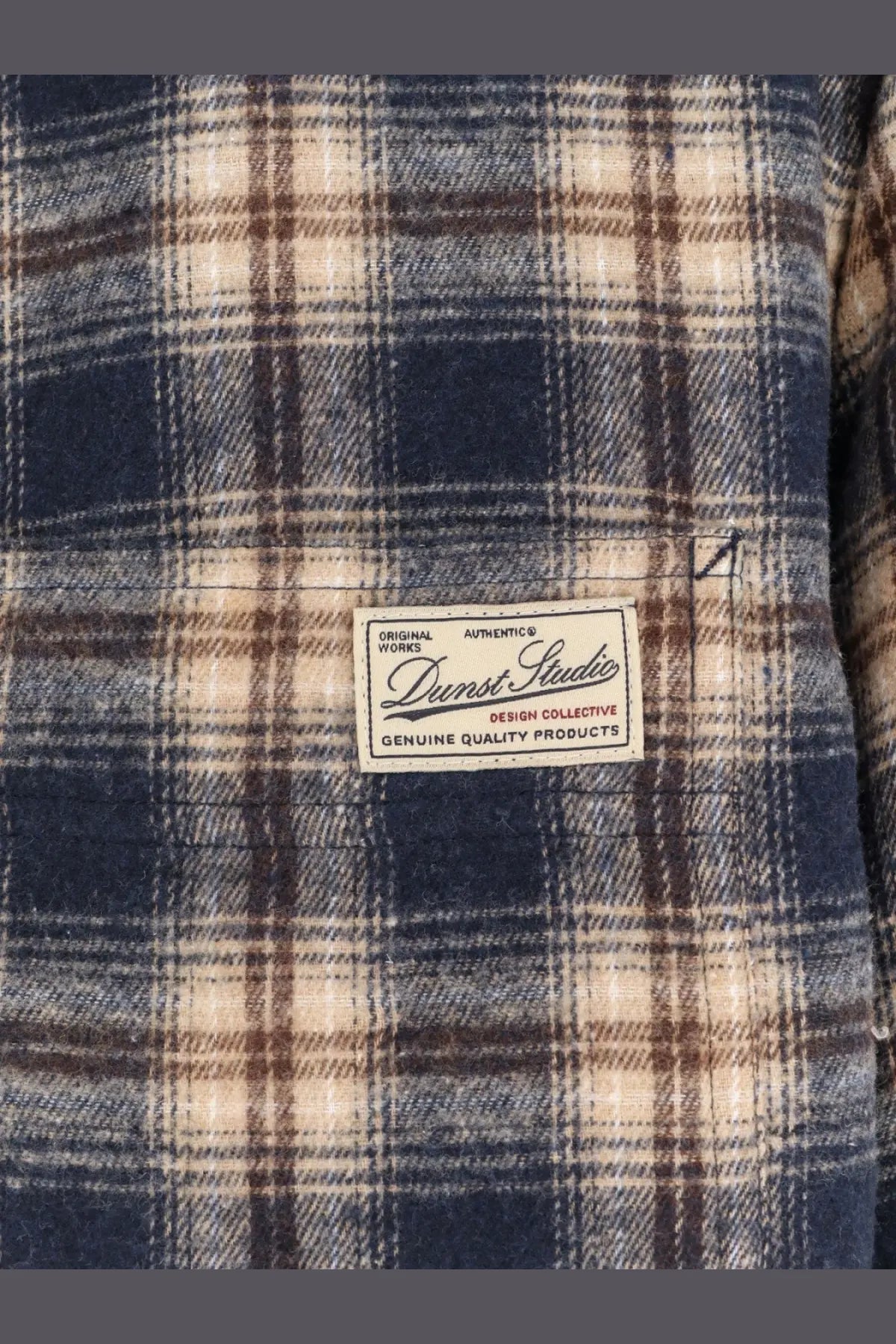 Dunst unisex madras pattern flannel jacket in navy blue and beige plaid with a white darnst studio label on the chest