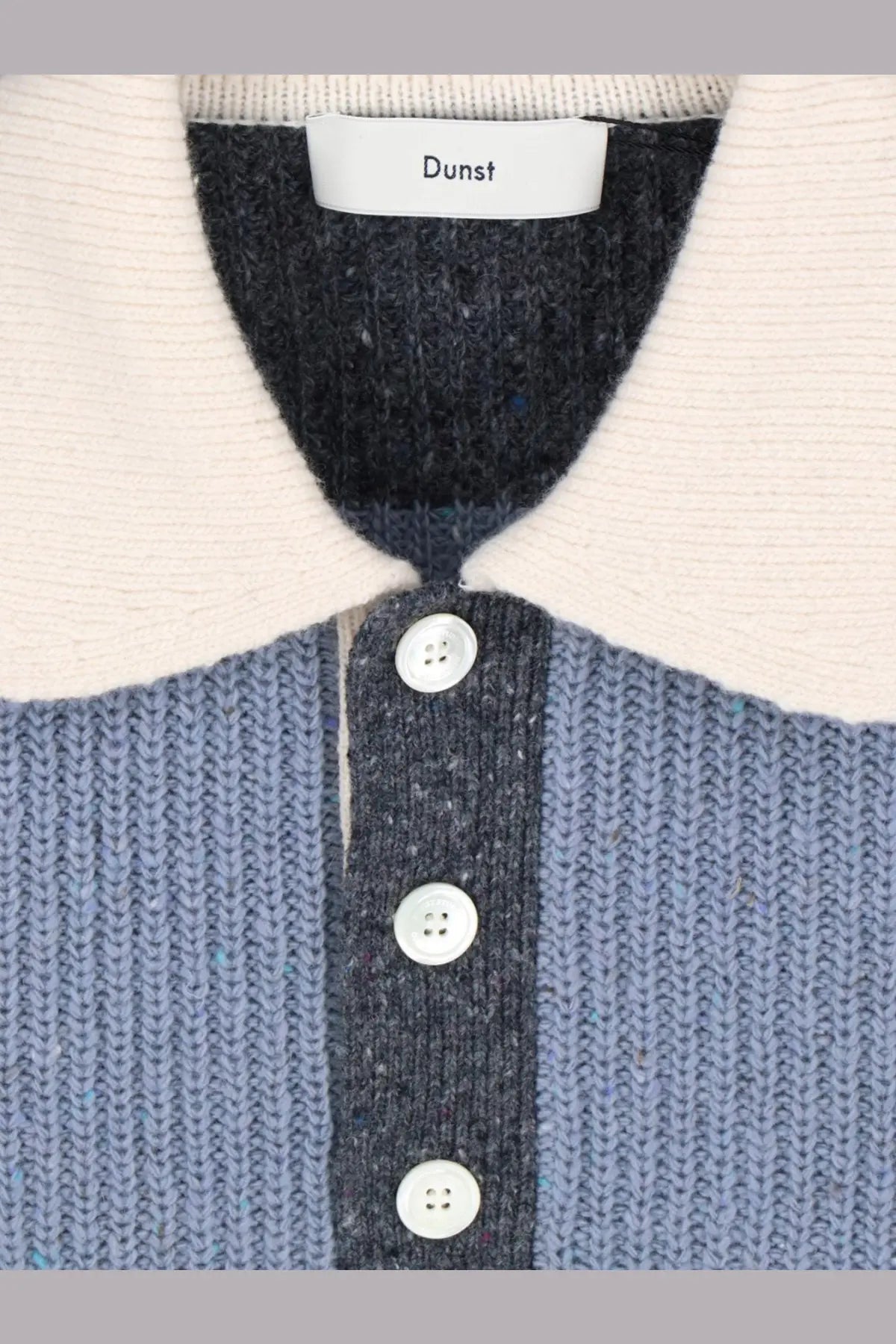 A dunst unisex wool blend knit cardigan with a blue body cream collar and white buttons