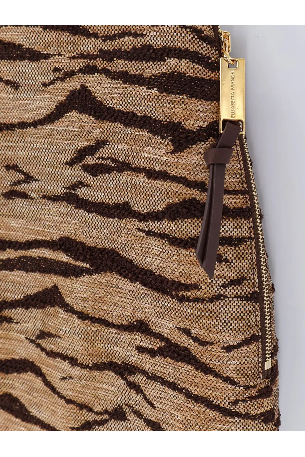 Tiger-print woven clutch with gold-tone zipper and brand tag paired with elisabetta franchi beige embroidered mini skirt