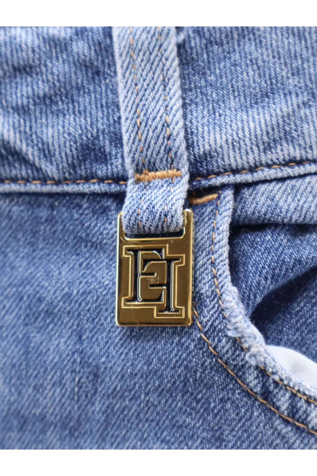 Gold-tone rectangular metal clasp with embossed et logo on light blue denim fabric of elisabetta franchi urban cotton jeans