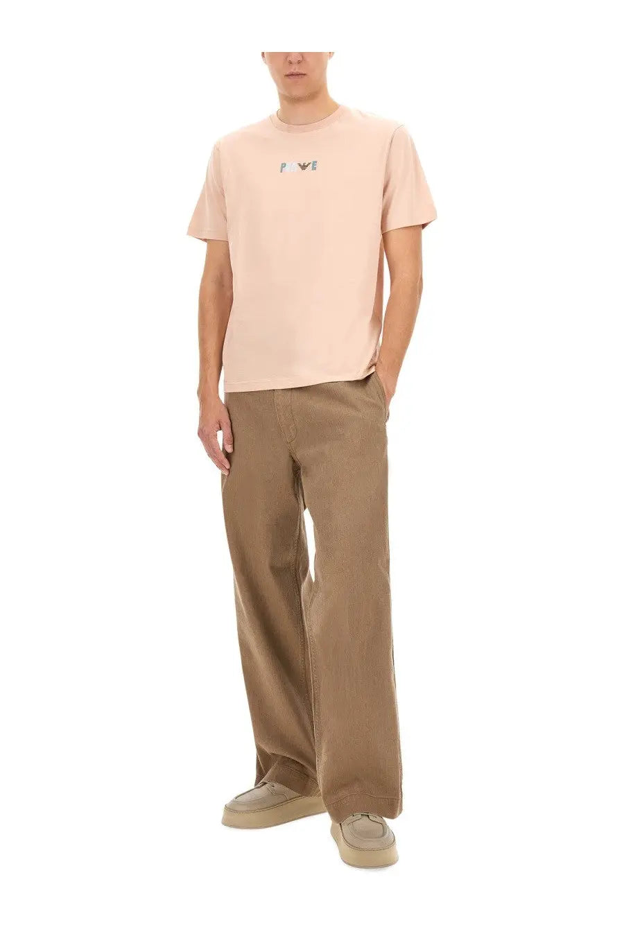 A pale pink short-sleeved t-shirt with a small embroidered logo paired with Emporio Armani men’s brown bull denim jeans