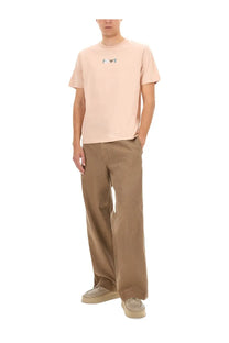 A pale pink short-sleeved t-shirt with a small embroidered logo paired with Emporio Armani men’s brown bull denim jeans