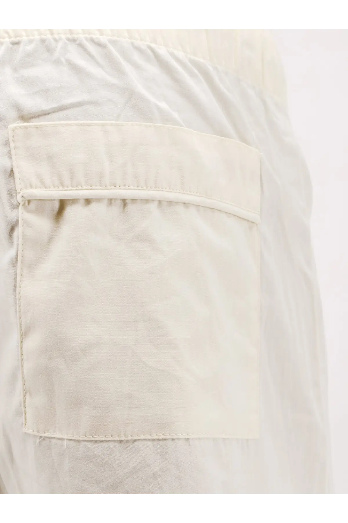 A cream-colored lightweight fabric pocket with neat stitching on entire studios unisex cotton bermuda shorts white