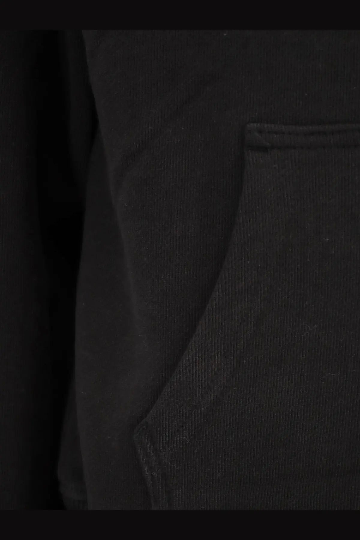 Black textured cotton fabric pocket with stitched edges on entire studios unisex standard hood sweatshirt