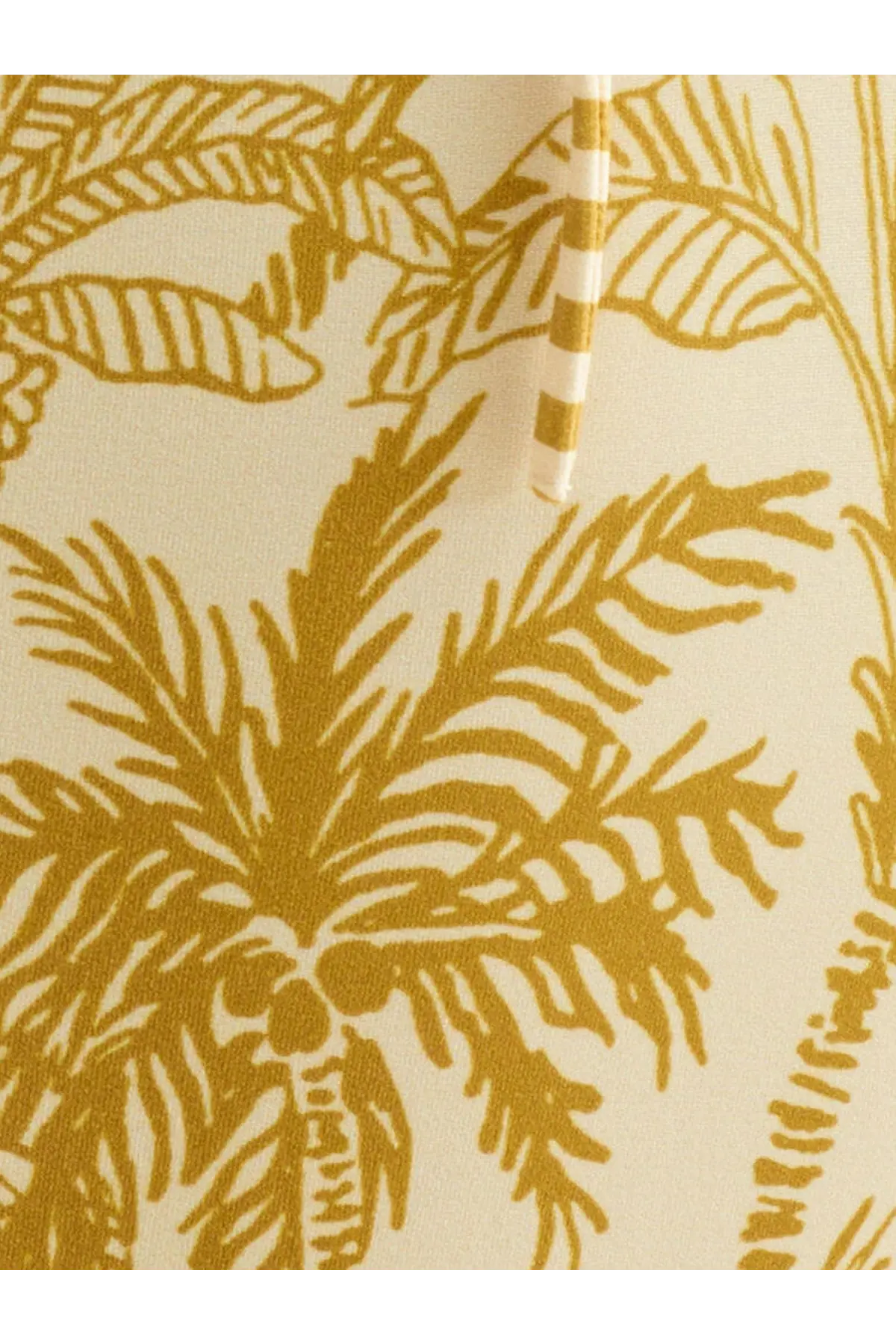 Cream-colored fabric one piece swimsuit with bold golden-yellow tropical palm tree pattern by Eres women’s gold collection