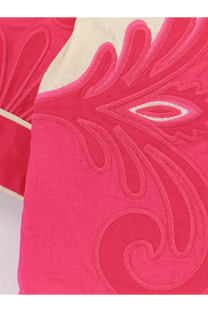 A vibrant pink embroidered cushion with cream border shown with farm rio women’s blue linen and viscose kimono