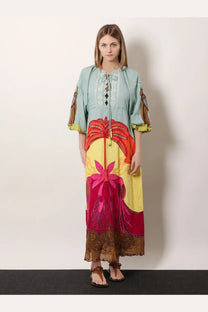 A woman wears a farm rio women’s usiacuri linen and viscose maxi dress in light blue with red and yellow floral embroidery