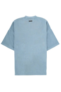 Fear of god essentials men’s light blue oversized t shirt with crew neck and black tag at back of collar