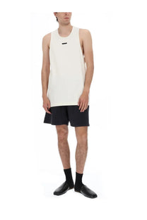Fear of god essentials men’s off-white sleeveless tank top in cotone with small black horizontal logo on chest