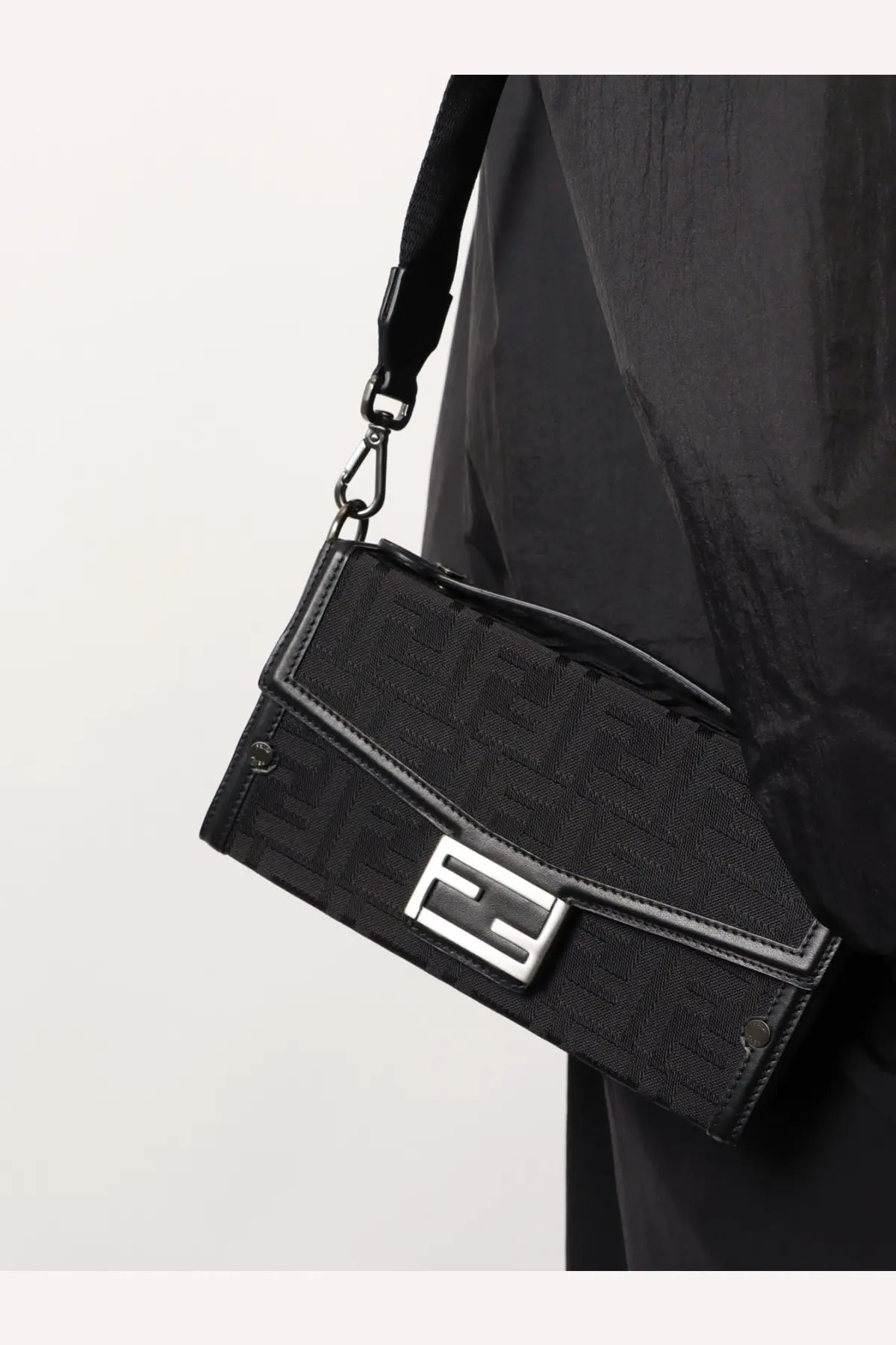 Fendi men’s baguette soft trunk black crossbody bag with repeating monogram fabric and silver-tone metal clasp