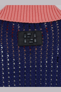 A navy blue knitted cotton sweater with a pink ribbed collar and black leather patch featuring the Fendi logo