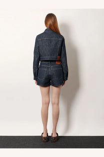 Back side of dark blue denim cropped jacket with brown leather patch on waistband from fendi women’s denim shorts blue