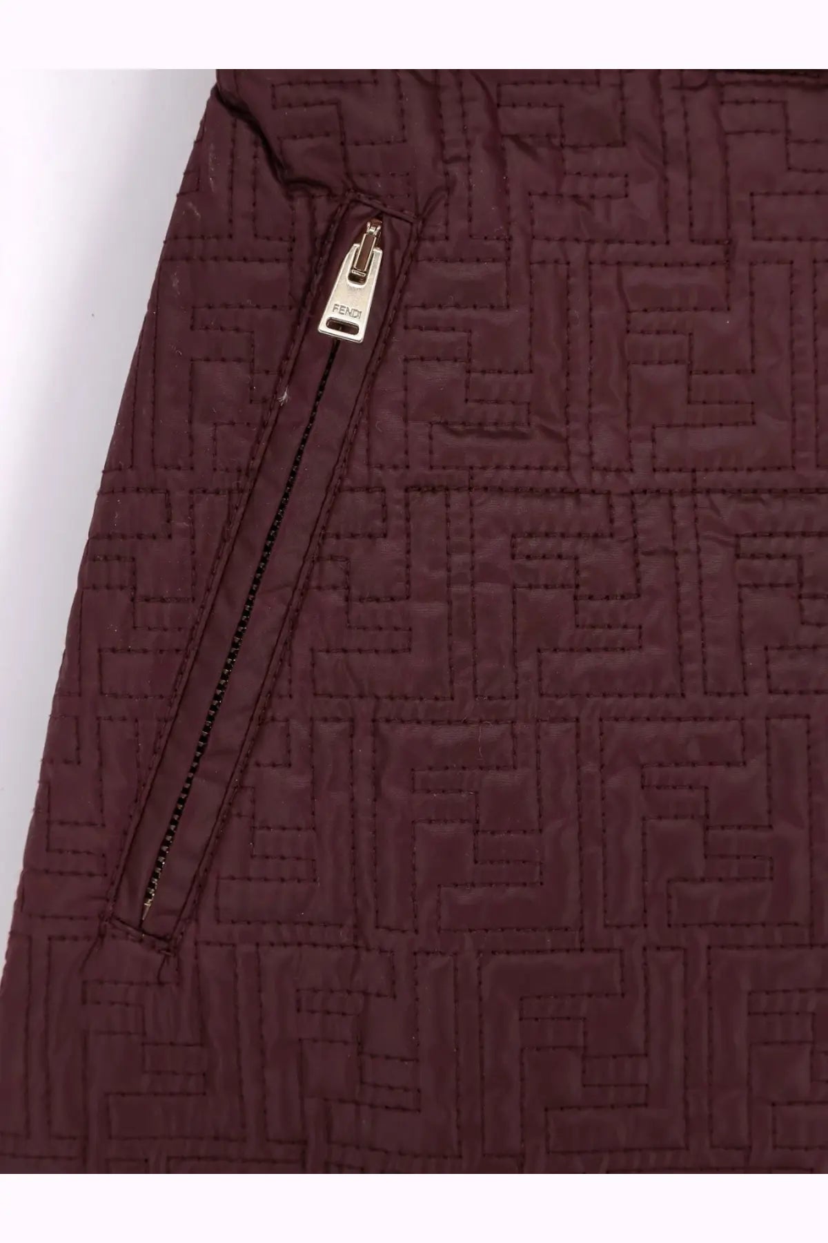 A maroon quilted Fendi jacket with a repeating monogram pattern and silver-toned zipper pull