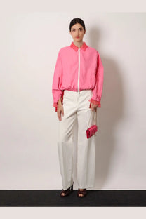 Pink satin clutch with chain strap paired with Fendi women’s white technical canvas trousers in a stylish look