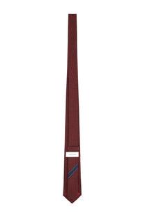 A sleek solid burgundy silk Ferragamo men’s cravatta with a subtle navy stripe and minimalist white brand label