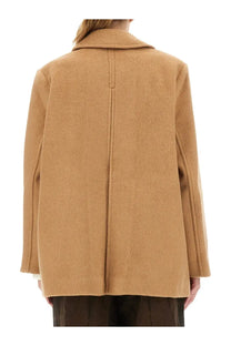 Camel colored oversized wool coat with structured collar and straight back seam shown from the back side