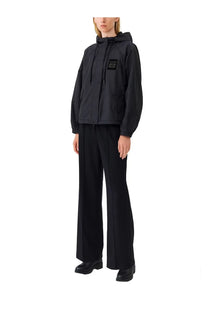 Ganni women’s black hooded jacket with a small rectangular patch on the left chest featuring white text and symbols