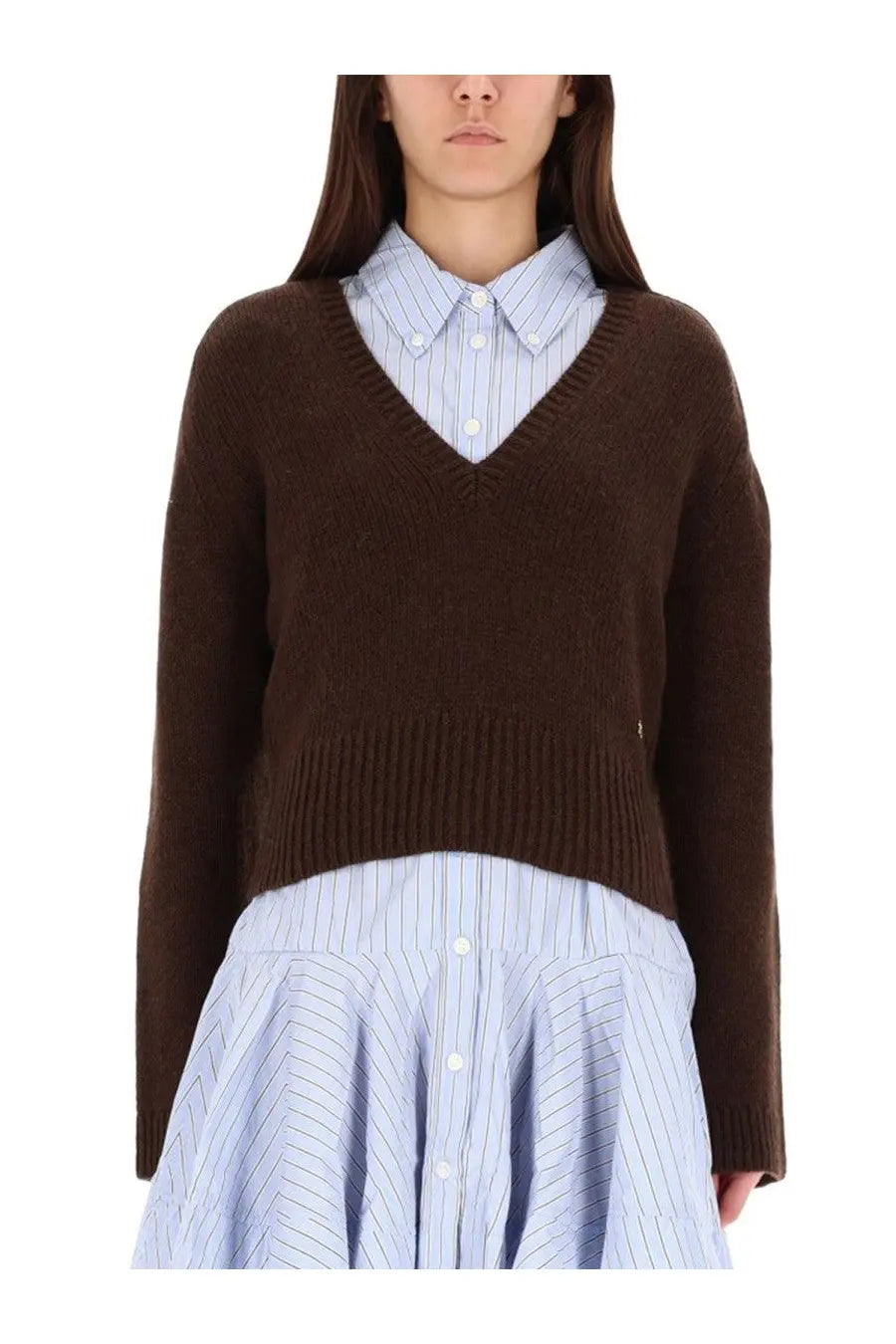 Ganni women’s brown v-neck knit sweater layered over a light blue and white striped button-up shirt