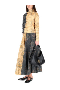 Black leather shoulder bag with gold-tone hardware and front flap closure paired with ganni women’s wheeled skirt multicolor