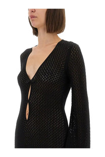 The garment women’s short dress Tanzania black is a black, long-sleeved knit dress with a deep v-neck and front bow detail