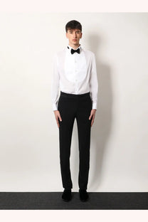 A man wearing a Giorgio Armani men’s white cotton tuxedo shirt with black bow tie and matching black trousers