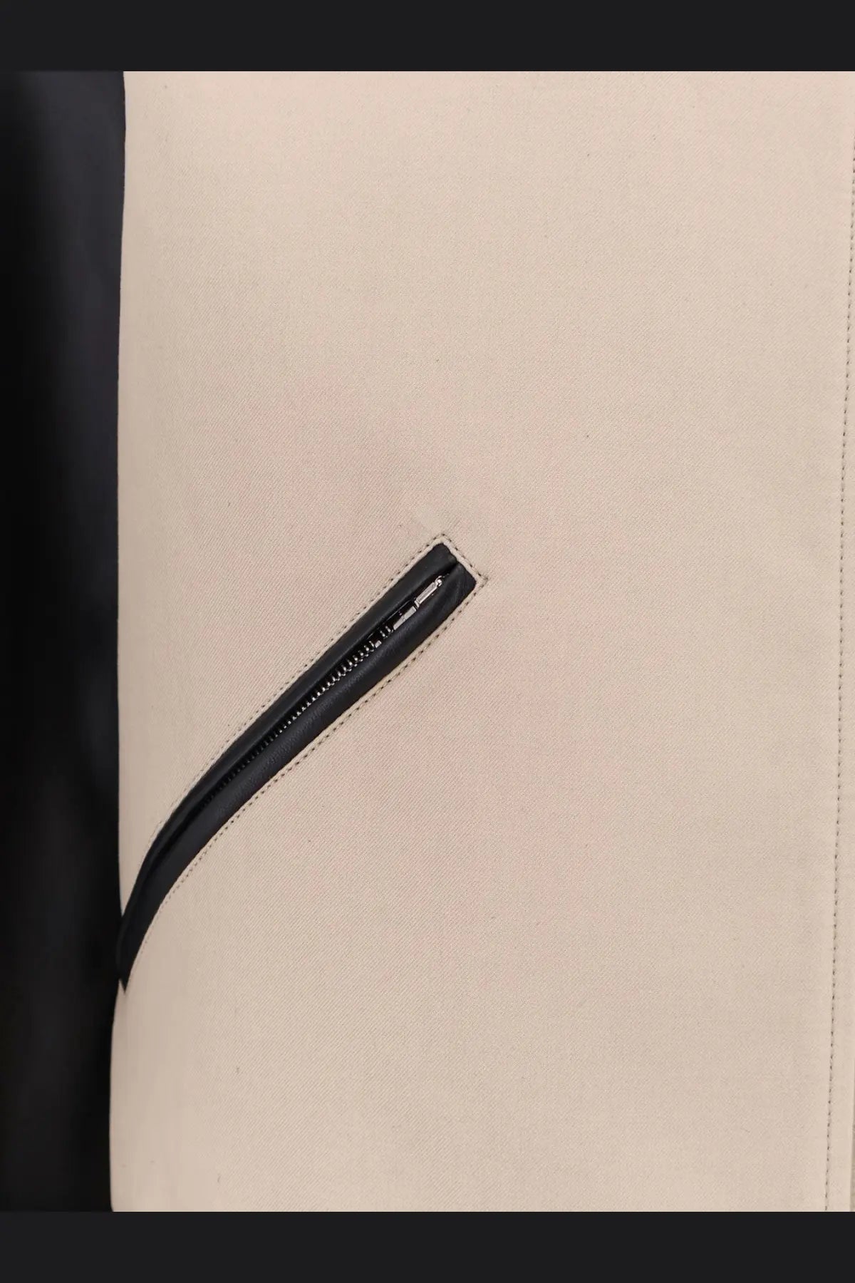 Beige canvas bag with black zipper pull and stitched seam shown with givenchy men’s cotton jacket black