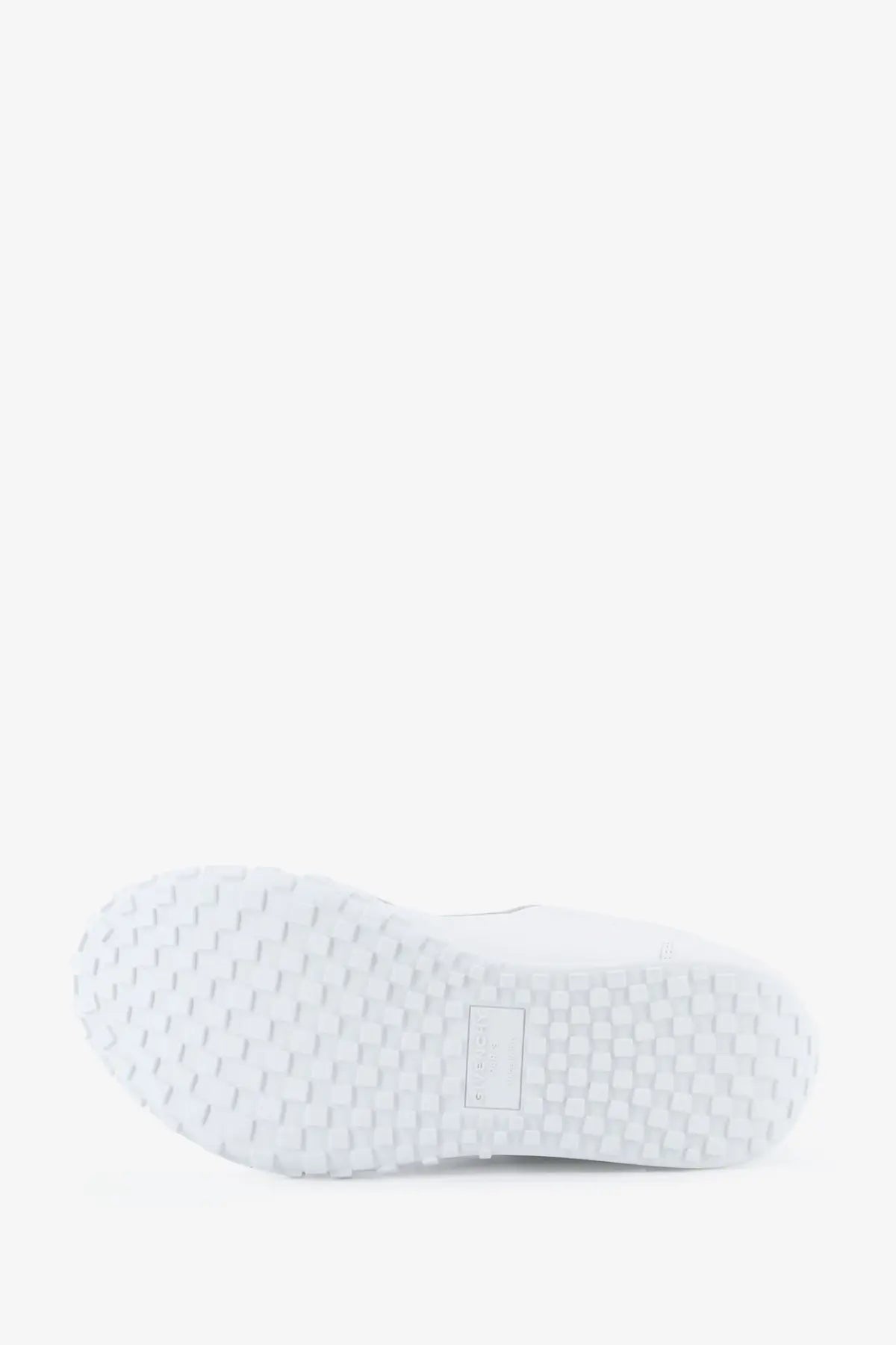 White rubber sole with textured hexagonal tread and rectangular label on givenchy men’s glide runner leather sneakers white back side