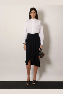 Black ruffled asymmetrical midi skirt paired with Givenchy women’s open back white cotton shirt shown from the front