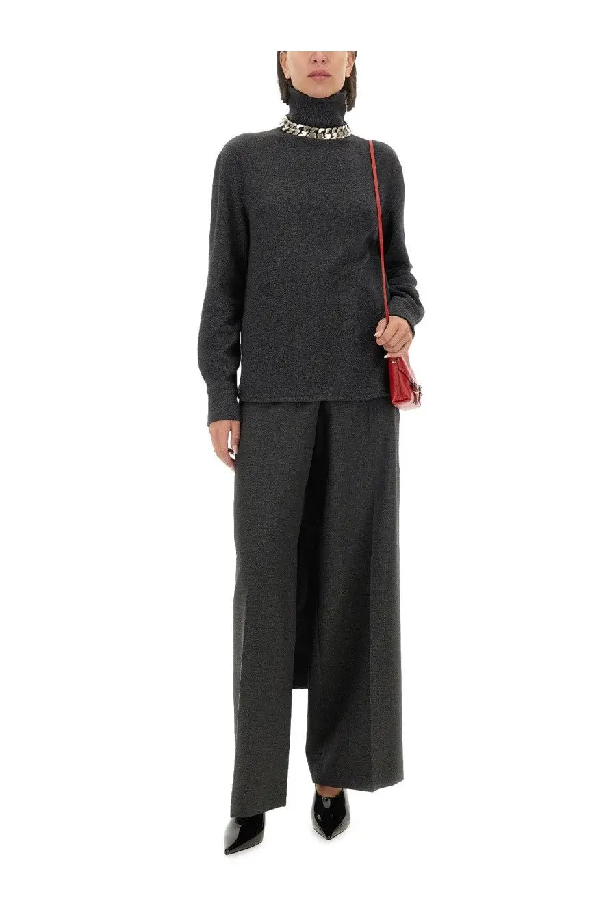 A sleek red leather crossbody bag with a structured rectangular shape and slender shoulder strap for Givenchy pants look