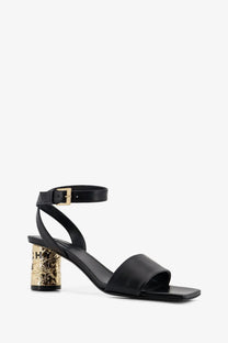 Givenchy women’s black leather sandals with gold embossed textured block heel and ankle strap visible from the back side