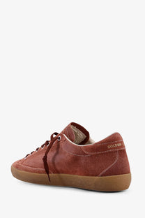 Back view of golden goose men’s super star double quarter rust-colored suede sneaker with tan sole and branding on heel