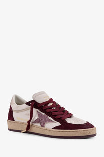 Golden Goose women’s Ballstar leather low-top sneaker in maroon and cream suede with a glittery star patch