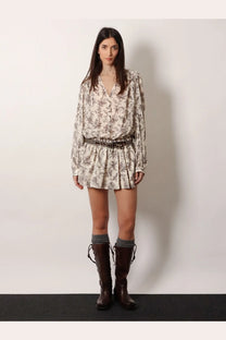 A woman wears a golden goose women’s black short cotton dress with a beige floral print romper and brown boots