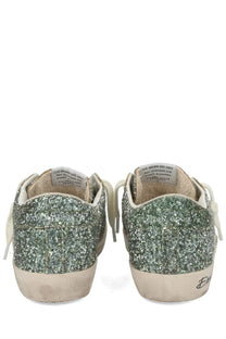 Golden Goose women’s Superstar sneaker in glittery green and silver with white laces and distressed beige sole
