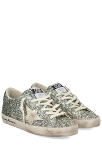 Golden Goose women’s Superstar sneaker in silver glitter with white laces and distressed rubber sole