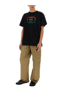 Black gucci t-shirt with bold red and green double g logo paired with beige gucci men’s cargo pants