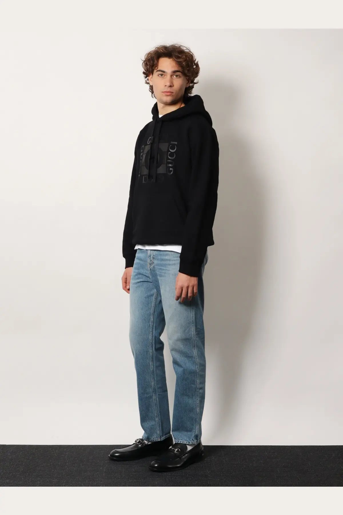 Black gucci hoodie with a bold logo print on the front paired with gucci men’s certified cotton slim fit blue jeans