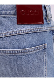 A glossy burgundy leather patch with embossed gucci logo on the back of light-wash gucci men’s slim fit denim jeans
