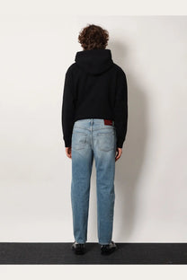 Gucci men’s certified cotton slim fit light-wash denim jeans with straight-leg cut and red leather patch at waistband