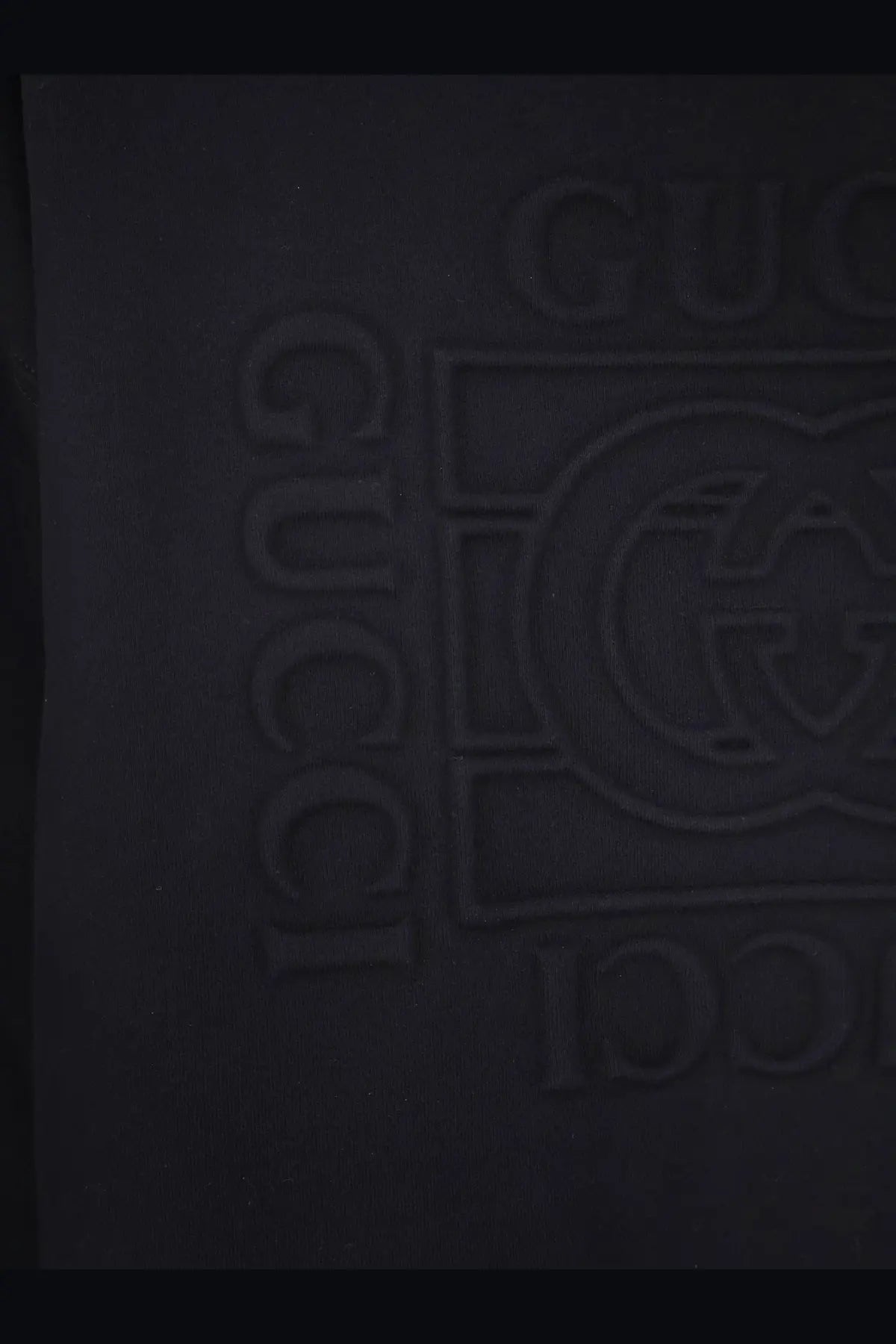 Black gucci logo embossed on dark fabric of gucci men’s cotton sweatshirt black