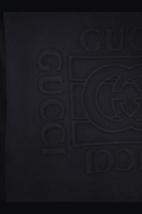 Black gucci logo embossed on dark fabric of gucci men’s cotton sweatshirt black