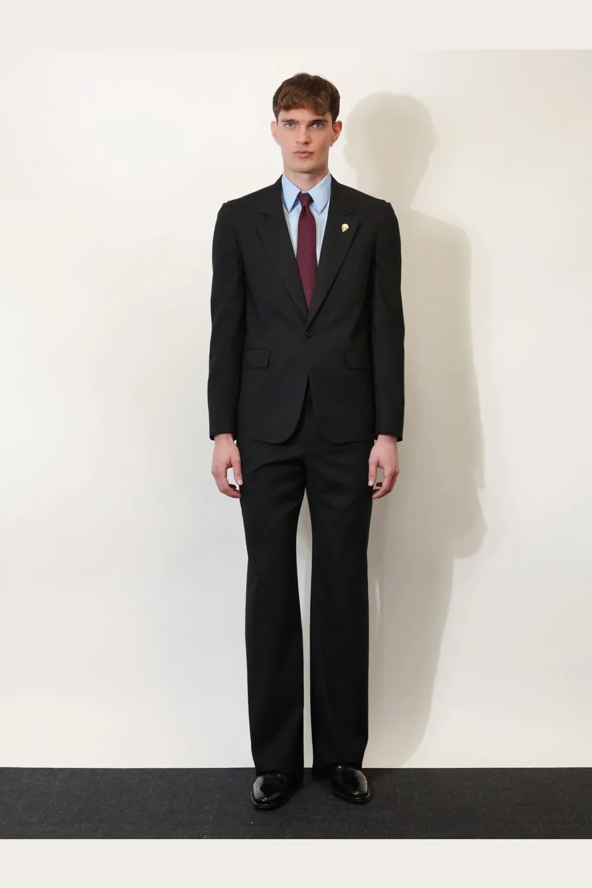 Black tailored Gucci men’s GG wool blend trousers paired with single-breasted jacket and burgundy tie